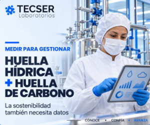 Operaria con guantes azules revisando indicadores ambientales en una tablet dentro de una planta cosmética de Tecser